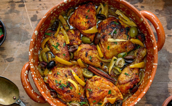 Chicken Tagine with Calamata Olives, Cracked Green Olives and Preserved Lemons in a pot on wooden table