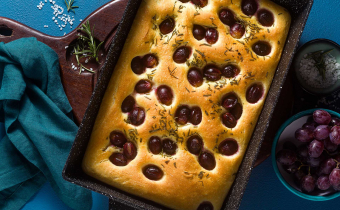 focaccia with red grapes on a blue table. Italian Cuisine, the perfect appetizer