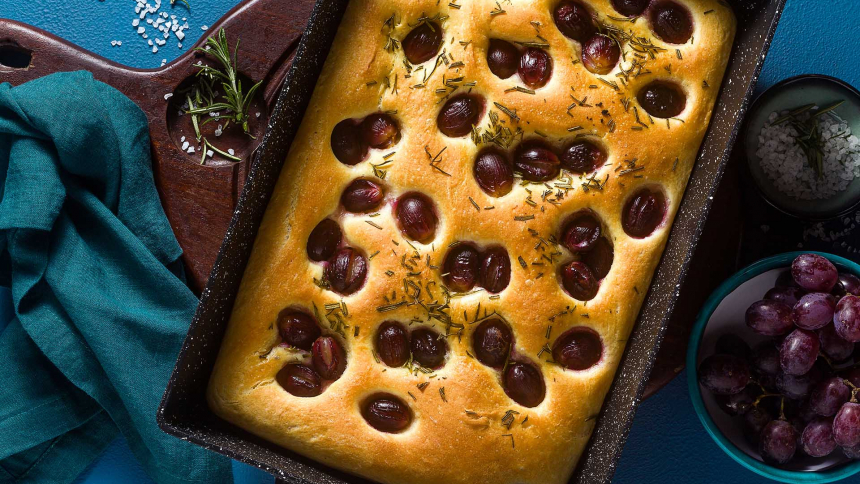 focaccia with red grapes on a blue table. Italian Cuisine, the perfect appetizer