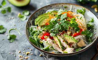 Generate an image of a vibrant chicken salad with vermicelli noodles, mint, cilantro, avocado, and toasted tamari seeds, beautifully plated asian style --chaos 10 --ar 16:9 Job ID: 27e663b1-0a17-4326-a16d-3f647d318db4